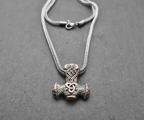 Thorshammer-Kette aus 925er Sterling Silber

Der massiv gearbeitete Thorshammer aus 925er Sterling Silber ist der Mittelpunkt dieser nordisch inspirierten Halskette.

Verschlungene Flechtornamente verzieren den Schaft des Mjölnir, während auf dem Hammerkopf eine Triskele sitzt. Die Vertiefungen sind dunkel abgesetzt und lassen die plastischen Details des Silberanhängers deutlich hervortreten.

Kombiniert ist der etwa 8,5 g schwere Anhänger mit einer 56 cm langen Fuchsschwanzkette aus Edelstahl. Geschlossen 