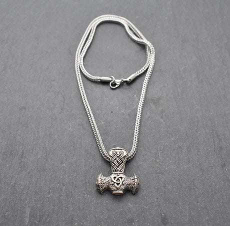 Thorshammer-Kette aus 925er Sterling Silber

Der massiv gearbeitete Thorshammer aus 925er Sterling Silber ist der Mittelpunkt dieser nordisch inspirierten Halskette.

Verschlungene Flechtornamente verzieren den Schaft des Mjölnir, während auf dem Hammerkopf eine Triskele sitzt. Die Vertiefungen sind dunkel abgesetzt und lassen die plastischen Details des Silberanhängers deutlich hervortreten.

Kombiniert ist der etwa 8,5 g schwere Anhänger mit einer 56 cm langen Fuchsschwanzkette aus Edelstahl. Geschlossen 