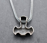 Rückseite mit Stempel der Thorshammer-Kette aus 925er Sterling Silber

Der massiv gearbeitete Thorshammer aus 925er Sterling Silber ist der Mittelpunkt dieser nordisch inspirierten Halskette.

Verschlungene Flechtornamente verzieren den Schaft des Mjölnir, während auf dem Hammerkopf eine Triskele sitzt. Die Vertiefungen sind dunkel abgesetzt und lassen die plastischen Details des Silberanhängers deutlich hervortreten.

Kombiniert ist der etwa 8,5 g schwere Anhänger mit einer 56 cm langen Fuchsschwanzkette a