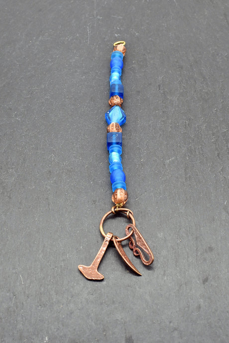 Authentischer Wikingerschmuck aus Bronze mit Mjölnir, Feuerstein und Druidensichel. Handgefertigte Fibelketten aus Glasperlen in blau und lachs – ideal für Reenactment, LARP und Mittelalterfans.