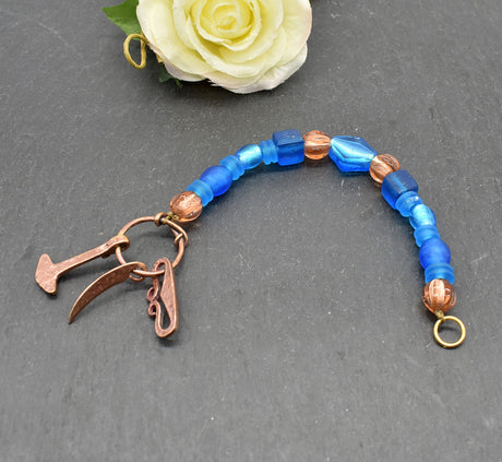 Authentischer Wikingerschmuck aus Bronze mit Mjölnir, Feuerstein und Druidensichel. Handgefertigte Fibelketten aus Glasperlen in blau und lachs – ideal für Reenactment, LARP und Mittelalterfans.