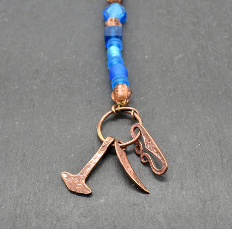 Authentischer Wikingerschmuck aus Bronze mit Mjölnir, Feuerstein und Druidensichel. Handgefertigte Fibelketten aus Glasperlen in blau und lachs – ideal für Reenactment, LARP und Mittelalterfans.