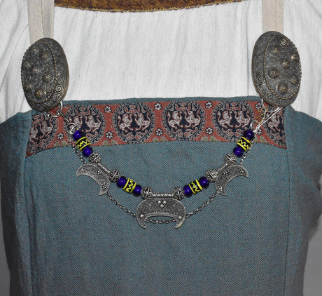 Lunula Fibelkette INGRID mit dunkelblauen Glasperlen mit gelbem Muster, sowie silbernen Perlen und Anhängern am Wikingerkleid