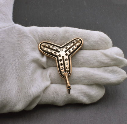 Birka Kleeblatt Fibel mit Kreisaugen aus Bronze auf der hand