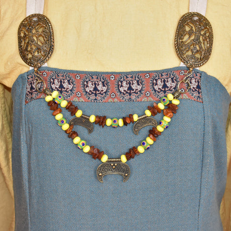 Tragebild am Wikinger-Kleid der Handgefertigte Wikinger Fibelkette mit Bernstein & Lunula-Amuletten, Glasperlen in gelb und grün
