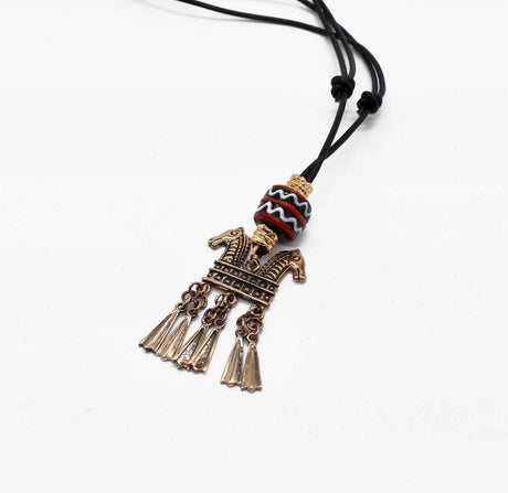 Keltische Halskette Echna aus Bronze, mit handgefertigter schwarzer Glasperle mit Muster aus rot und weiß, sowie vergoldeten Metallperlen an einem verstellbaren Lederband.
