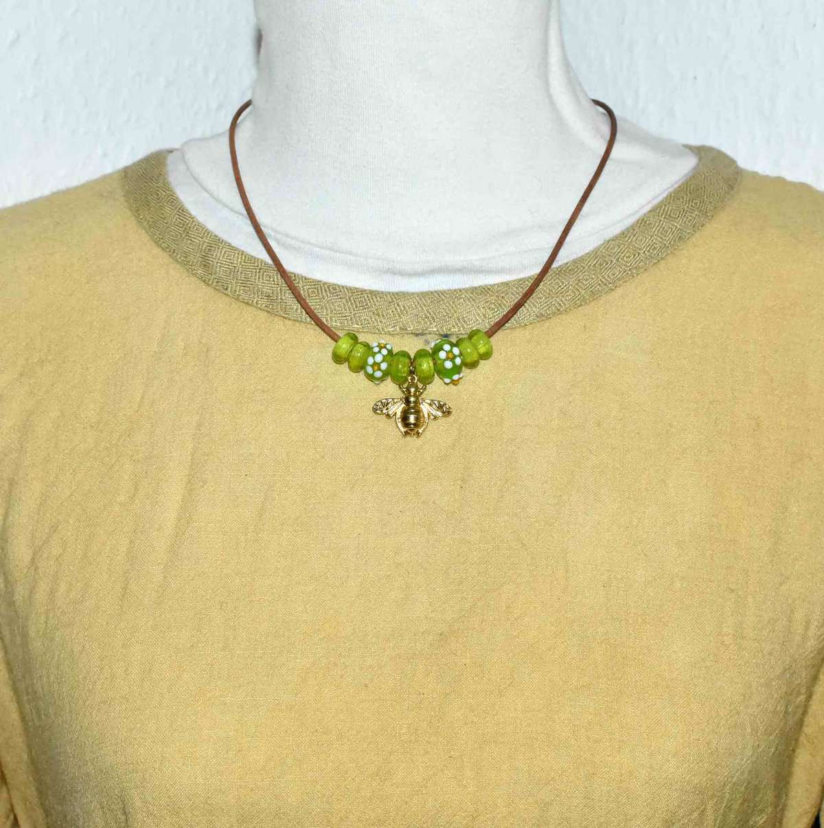 Tragebild der Power Bienenkette mit grünen Glasperlen auf Ledercollier