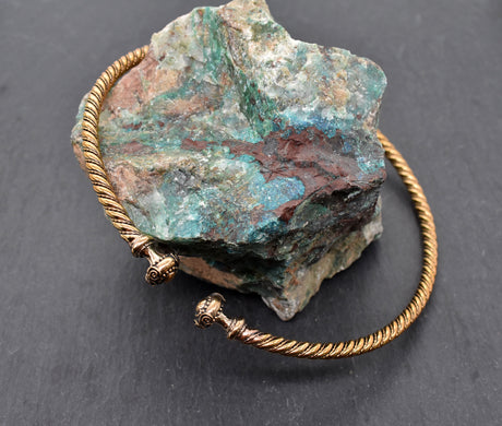 Keltischer Torque aus Bronze – Halsreif aus der La-Tène-Zeit für Frauen und Männer auf einem Stein