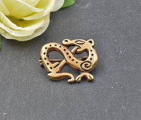 Drachen Fibel im Ringerike Stil aus Bronze auf einer Schieferplatte mit gelber Rose