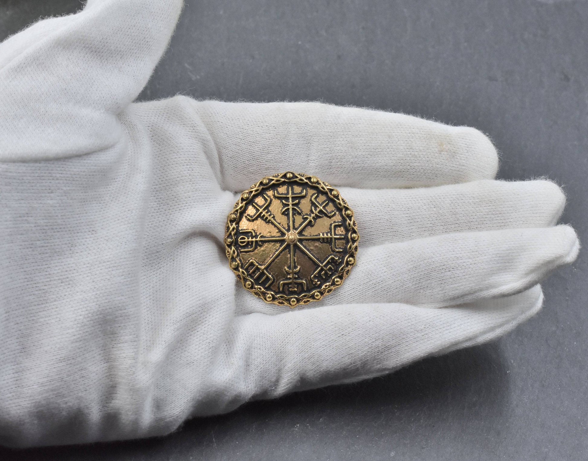 Mittelalterliche Brosche mit Vegvisir aus Bronze auf der Hand