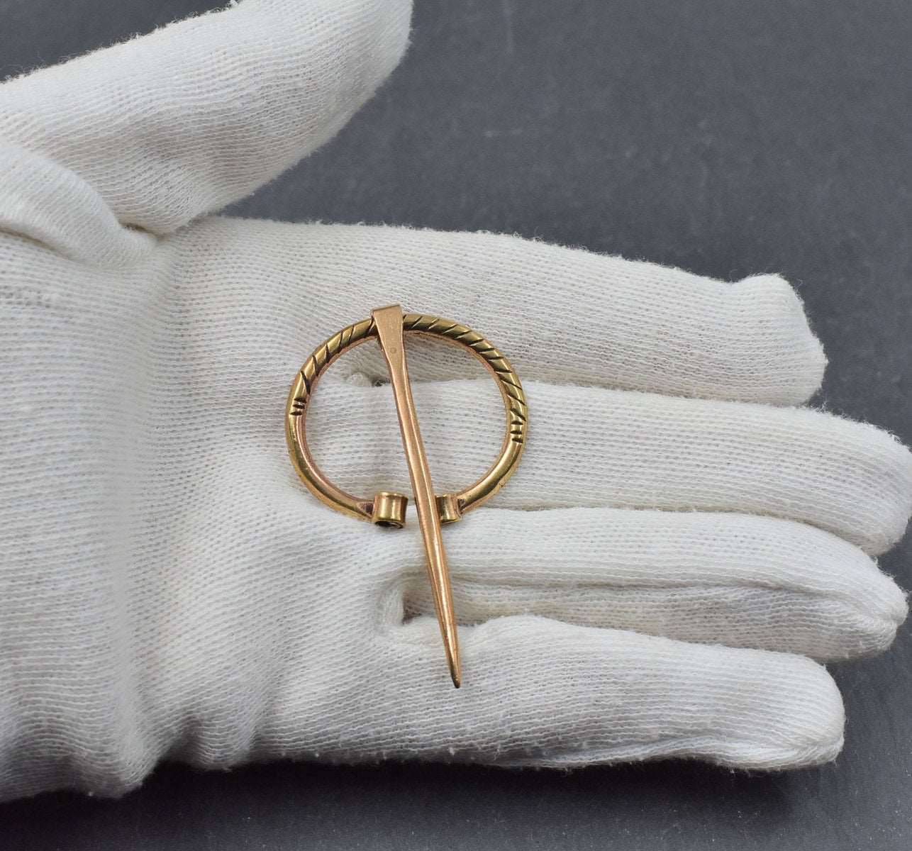 Kleine Wikinger Ringfibel aus Bronze auf der Hand